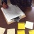 Photo of someone writing on a clipboard with post it notes surrounding her